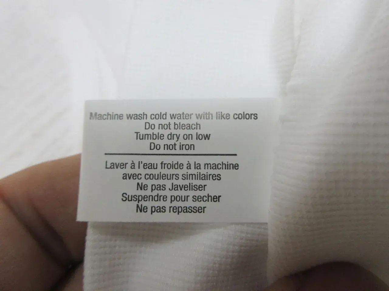Garment care label checked against buyer requirements before shipment.