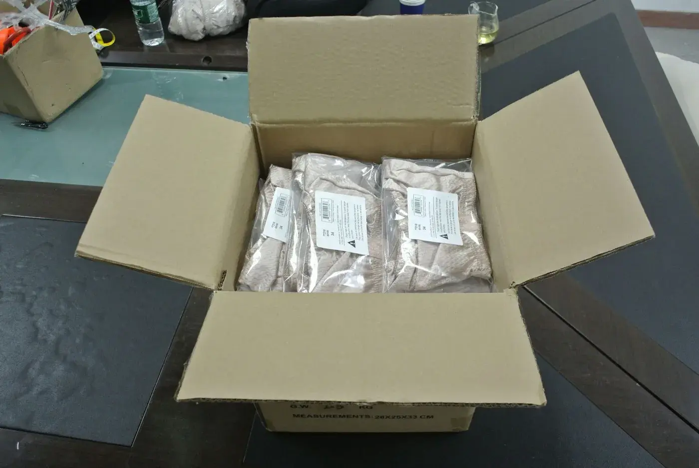 Open export carton showing individually packed products and labels ready for packing verification.