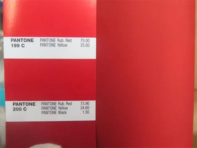 Pantone color references placed on a red product surface for inspection comparison.