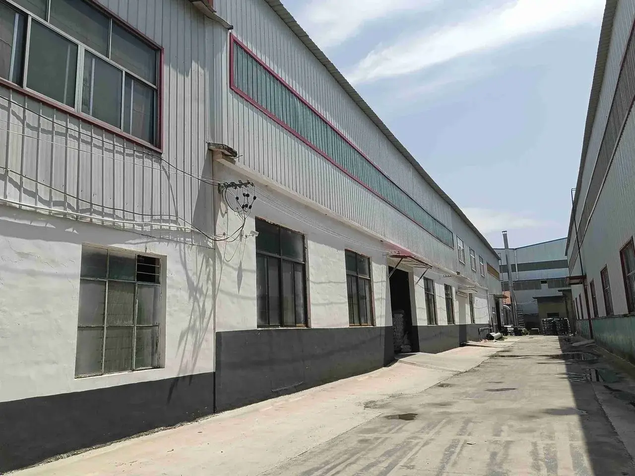 Cour d'usine et zone d'entrepot aux Philippines utilisees pour la planification des inspections et le suivi de production.