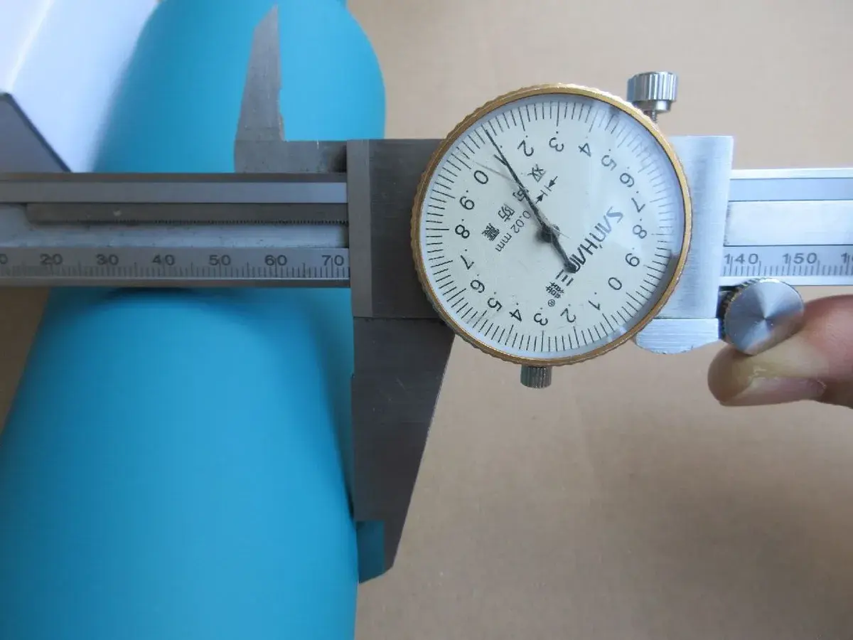 Inspector measuring a sampled product with a dial caliper.